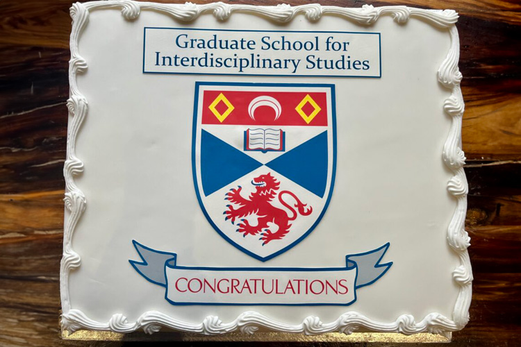 A cake featuring the University of St Andrews crest with the text Graduate School for Interdisciplinary Studies Congratulations